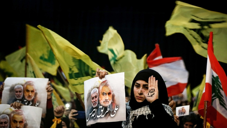 Teilnehmer einer Kundgebung halten Bilder des Generals Soleimani in die Höhe.