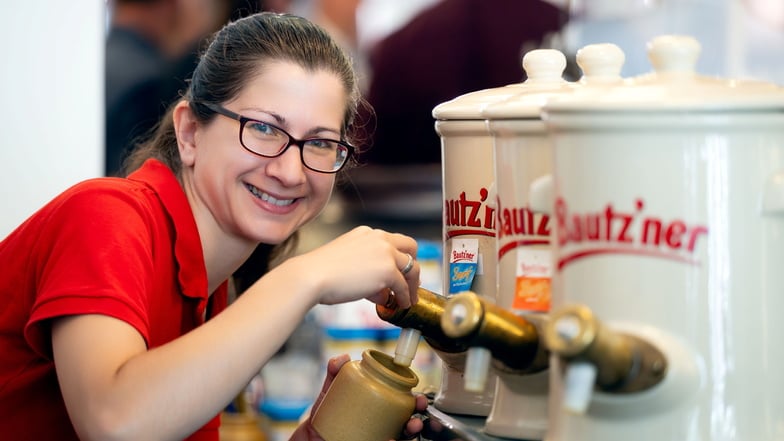 In der Senfmanufaktur mit Museum am Bautzener Fleischmarkt können Besucher zahlreiche Senfsorten probieren - während der Senfwochen auch eine exotische, limitierte Kreation. Verkäuferin Katharina Davideit zapft sie aus großen Behältern.