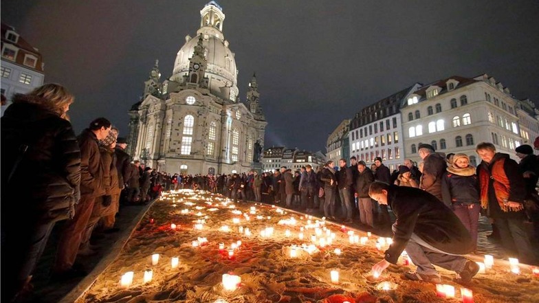 Kerzen stehen vor der Frauenkirche in Dresden.