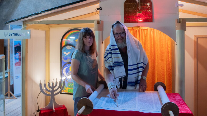 Claudia Schmidt und der ehemalige Gemeindepädagoge Kurt Morgenroth, die Besucher ehrenamtlich durchs Bibelland in Oberlichtenau führen, demonstrieren das Lesen der Thora in der neuen Synagoge.
