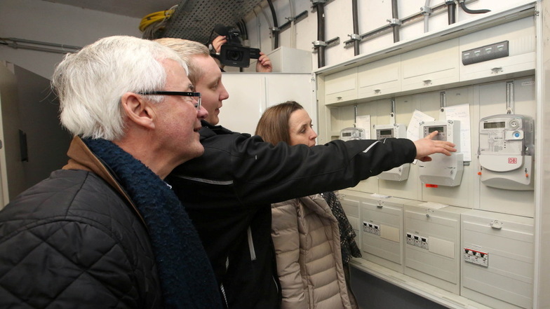 Peter Krotz und Justus Hering von Ampere Solare zeigen Kämmerin Friederike Trommer, wie der Stromzähler der PV-Anlage funktioniert.