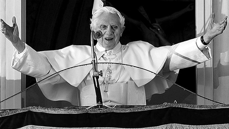 Der damalige Papst Benedikt XVI. grüßt 2013 eine jubelnde Menge, die sich vor dem Balkonfenster der päpstlichen Sommerresidenz Castel Gandolfo am Stadtrand von Rom versammelt hat.