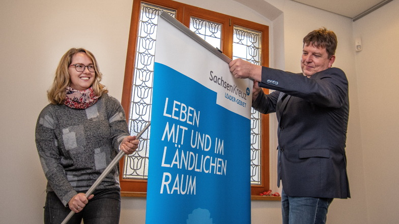 Harthas Wirtschaftsförderin Nicole Salzbrenner und Bürgermeister Ronald Kunze öffnen das RollUp vom Sachsenkreuz+.