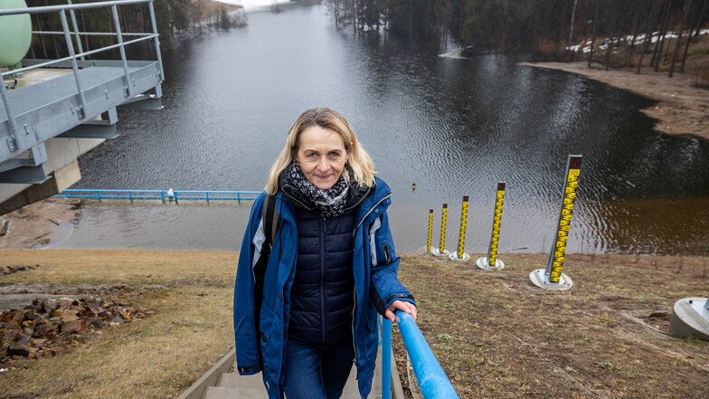 Birgit Lange von der Landestalsperrenverwaltung steht vor dem angestauten Hochwasserrückhaltebecken im Pöbeltal.