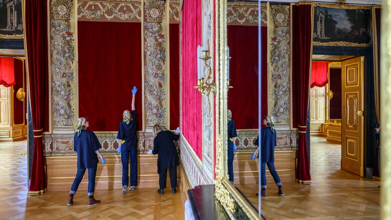 Textilrestauratorinnen arbeiten an der Hängung der letzten Wandteppiche in den Königlichen Paraderäumen im Residenzschloss.