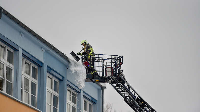 Per Drehleiter ging es am Donnerstagvormittag für Feuerwehrleute an der Bautzener Max-Militzer-Grundschule in die Höhe. Sie beseitigten holten schwere Schneebretter vom Dach.