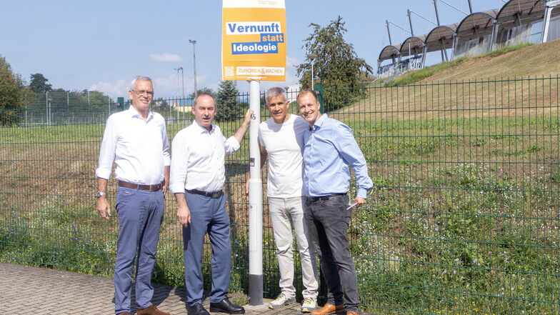 Thomas Weidinger, Hubert Aiwanger, Matthias Berger und Lucas Partuscheck bringen ein Wahlplakat der Freien Wähler in Riesa neben dem Riesaer Leichtathletikstadion in der Pausitzer Delle an.