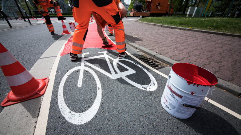Ein Arbeiter streicht Signalfarbe auf einen Radweg. In Sachsen sind noch 450 Kilometer zu sanieren oder komplett neu zu bauen. Geht das im bisherigen Tempo weiter, braucht man dafür 28 Jahre.