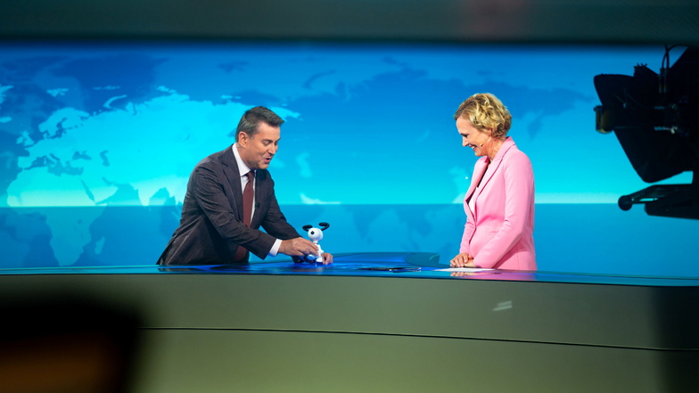 Moderator Jens Riewa (l-r) überreicht Moderatorin Caren Miosga am Ende ihrer letzten Sendung eine Snoopy-Figur.