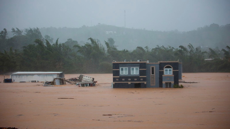 Drei Menschen warten in einem Haus auf Rettung vor den Überschwemmungen, die der Hurrikan Fiona in Cayey, Puerto Rico, verursacht hat.