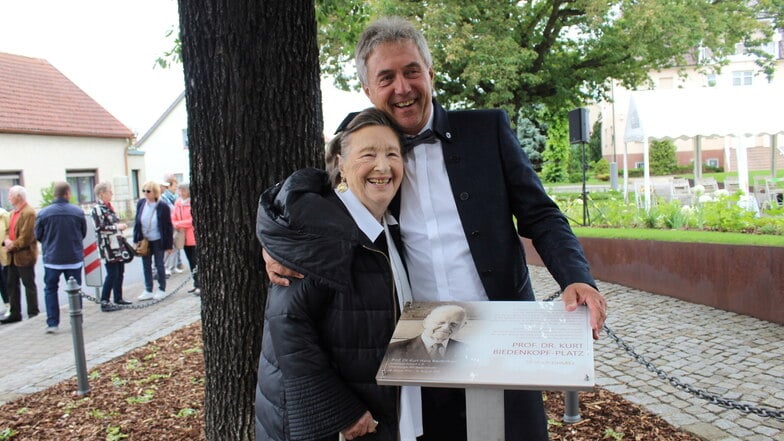 Der Gröditzer Bürgermeister Jochen Reinicke nimmt Ingrid Biedenkopf an der Gedenktafel für ihren im letzten Jahr verstorbenen Ehemann Kurt Biedenkopf in den Arm.