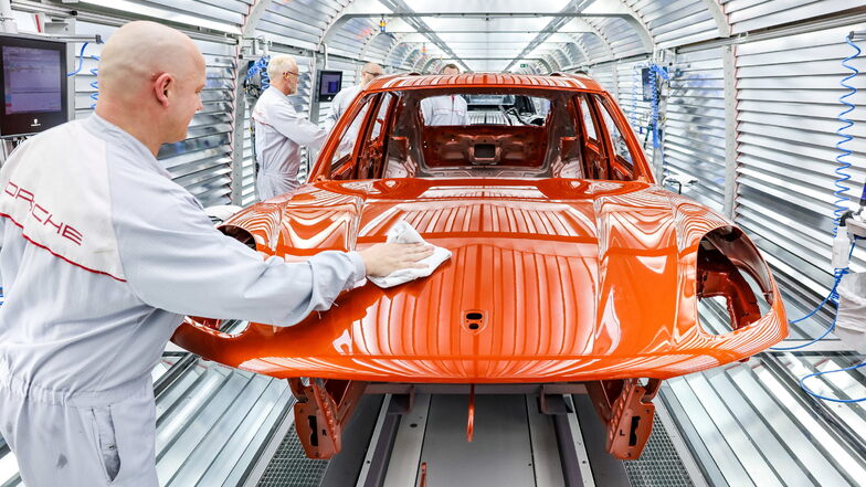 Leipzig: Mitarbeiter der Lackiererei arbeiten in der Qualitätskontrolle an einem Porsche Macan im Werk Leipzig.