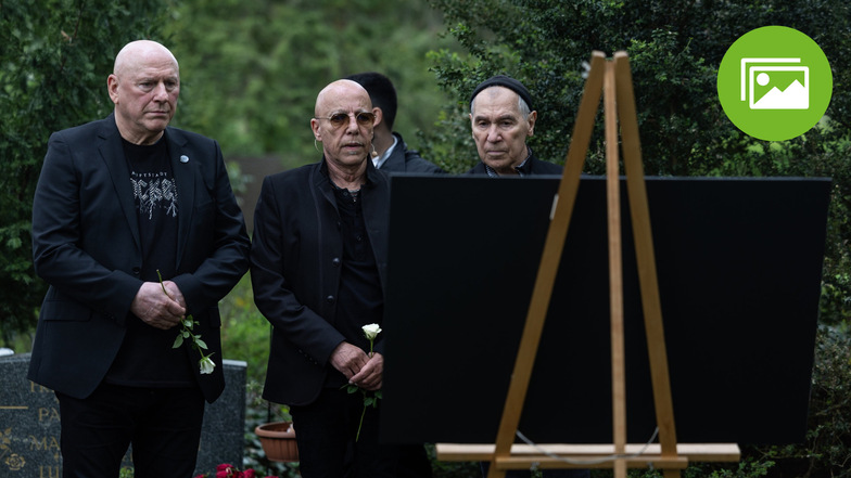 Die ehemalige City-Bandmitglieder Manfred Hennig (l-r), Toni Krahl und Georgi Gogow stehen am Grab von Fritz Puppel.