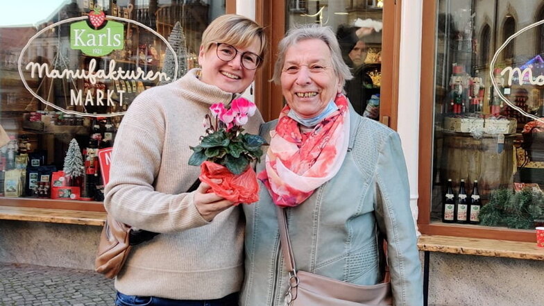 Christine Meier (rechts) ist die erste Kundin in Karls Manufakturenmarkt. Sie hat Marketingleiterin Nadia Schriever zur Begrüßung ein Alpenveilchen mitgebracht.