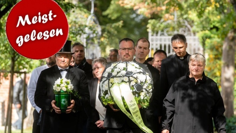 Neukirchs Friedhofsverwalter Lutz Schmidt trägt die Urne zum Grab. Bestattungsmeister Marcus Katzer trägt den Blumenschmuck. Rund 80 Trauergäste begleiteten Gerald „Opi“ Opitz am Freitag auf seinem letzten Weg.
