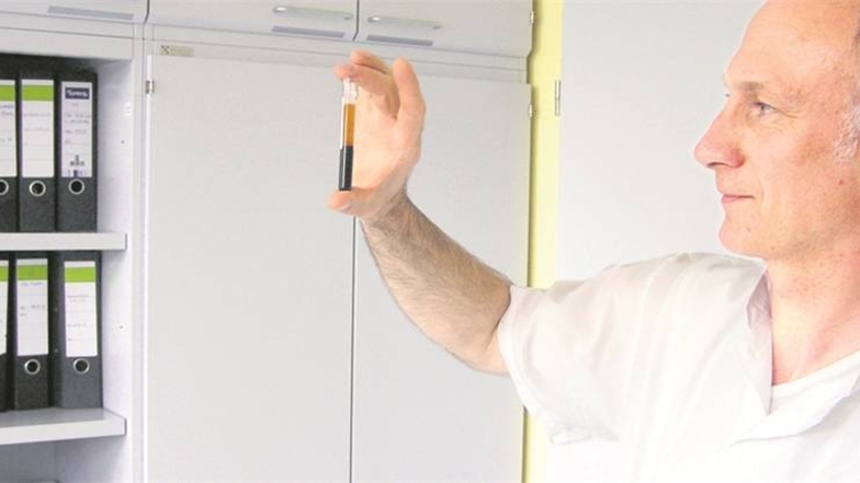 Thomas Blankenburg inspiziert in seinem Chemnitzer Büro ein Probenröhrchen mit zentrifugiertem Blut.