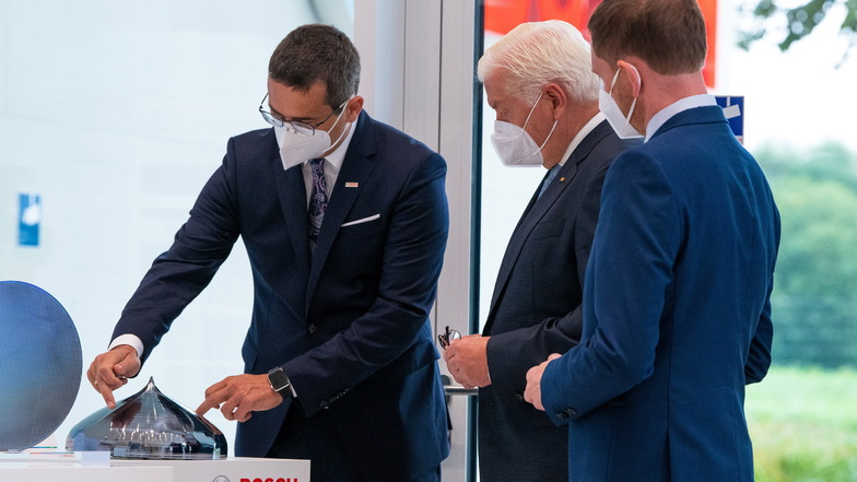 Technik zum Anfassen: Bosch-Werkleiter Christian Koitzsch (von links) zeigt dem Bundespräsidenten und Sachsens Ministerpräsidenten einen Siliziumkristall. Daraus werden die Scheiben geschnitten, die Grundlage für die Mikrochipproduktion sind.