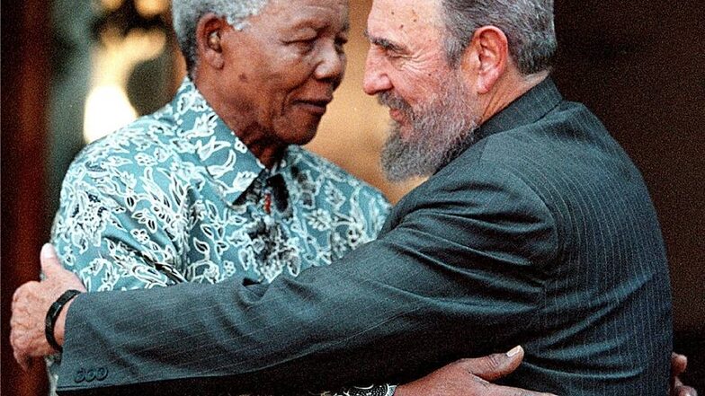 2001: Zwei Freiheitskämpfer und spätere Präsidenten liegen sich in den Armen - Südafrikas Nelson Mandela umarmt seinen Gast