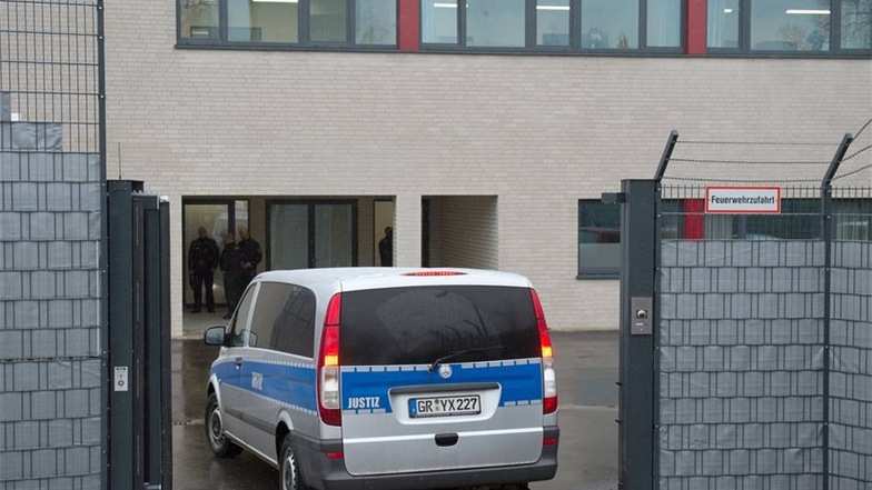 Ein Fahrzeug der Justiz fährt durch ein Tor des Gerichtsgebäudes des Oberlandesgerichts.