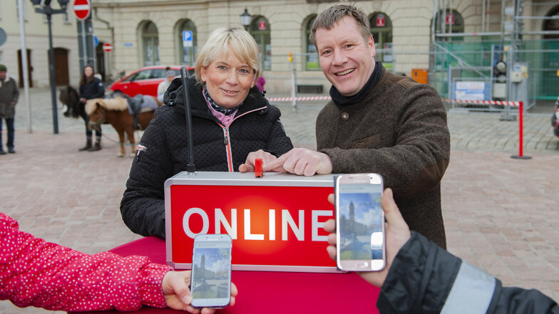 Der Großenhainer Oberbürgermeister Sven Mißbach und Angelika Pietzsch von der Händlerinitiative „Großenhain aktiv“ drücken am 12. April auf den roten Knopf, mit dem der Hotspot am Rathaus gestartet wurde.