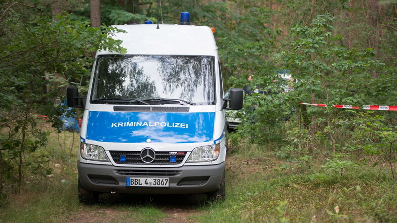 Ein Wagen der Kriminalpolizei steht in einem Wald bei Oranienburg. Hier fanden Besucher einer dortigen Bunkeranlage vor rund einer Woche die Leiche einer jungen Frau.