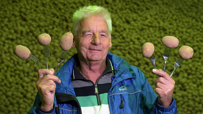 Winfried Hunold hat einige Kartoffeln auf Gabeln aufgespießt.