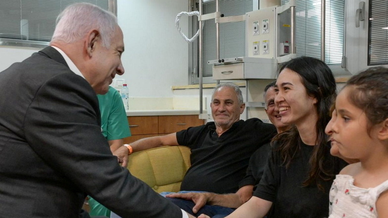 Israels Premierminister Benjamin Netanjahu (l) schüttelt der israelischen Geisel Noa Argamani (2.v.r.), 26, im Sheba Tel-HaShomer Medical Centre, die Hand, nachdem sie von der israelischen Armee aus der Gefangenschaft im Gazastreifen befreit wurde.