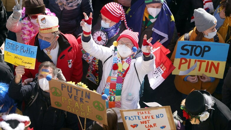 Teilnehmer der Friedensdemonstration am Rosenmontag halten Plakate mit der Aufschrift "Stop Putin".