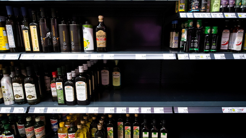 Flaschen mit Öl stehen in einem Regal in einem Supermarkt. Unternehmen der Lebensmittelbranche bekommen den Mangel an Speiseöl derzeit stark zu spüren.