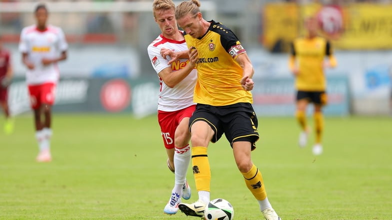 Vinko Sapina setzt sich gegen Regensburgs Sebastian Ernst durch. Zur Pause musste Dynamos Neuzugang von Rot-Weiss Essen verletzt ausgewechselt werden.