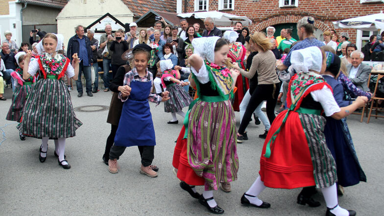 Kinder des Sorbischen Kindervereins Zeißig zeigen beim Frühlingsfest vor dem Zeißighof traditionelle Tänze wie „stup dale“ und die Annemarie-Polka.