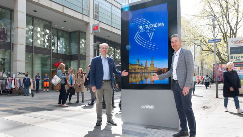 Wall-Geschäftsführer Patrick Möller (l.) und Baubürgermeister Stephan Kühn zeigen die neuen digitalen Werbetafeln an der Prager Straße in Dresden.