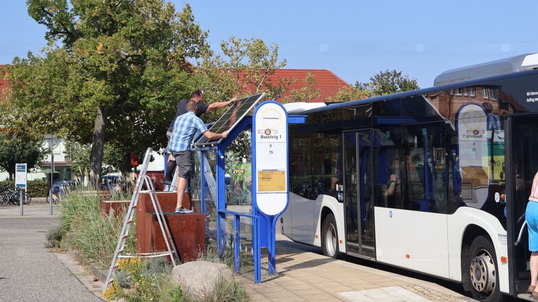 Auf dem Dach des Fahrgastunterstands am ersten Bussteig montierten Thomas Schneider vom Wirtschaftshof und Ideengeber Tomasz Regel (vorn) das Solarpaneel.