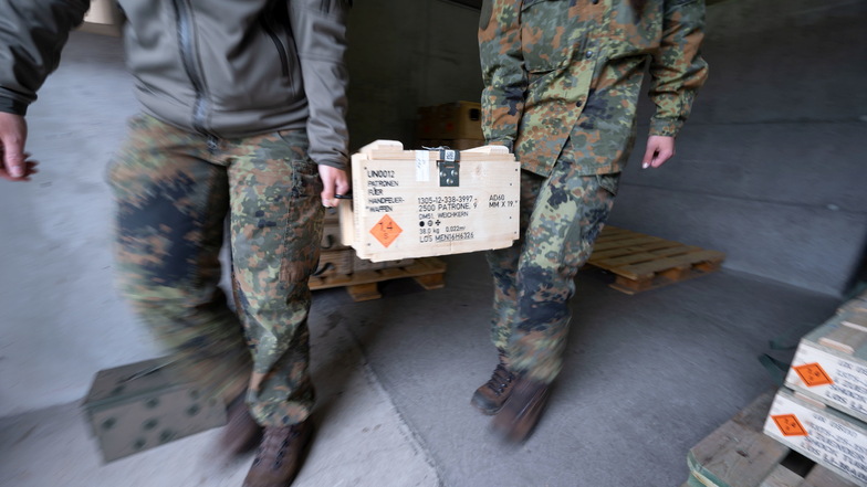 Mitglieder des Kommando Spezialkräfte (KSK) der Bundeswehr tragen eine Munitionskiste aus einem Munitionslager.
