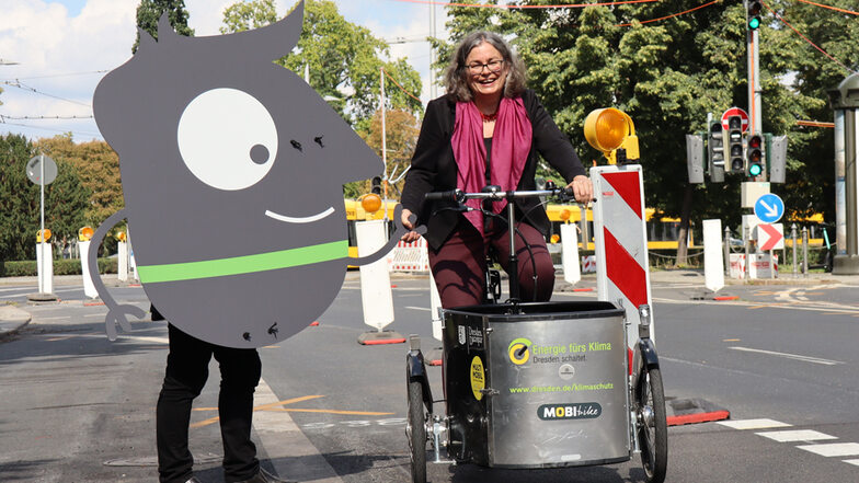 Edgar, das Maskottchen der Mobilitätswoche, zeigt Umweltbürgermeisterin Eva Jähnigen den fast fertigen neuen Radstreifen an der Albertstraße.