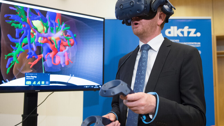 Michael Kretschmer betrachtet im Nationalen Zentrum für Strahlenforschung in der Onkologie mithilfe einer VR-Brille eine vom Krebs befallene Leber.