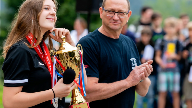 Emely Dittrich mit Pokal und Heimtrainer Heiko Kött. An der Sebnitzer Oberschule wurde sie von ihren Mitschülern und Lehrern empfangen.