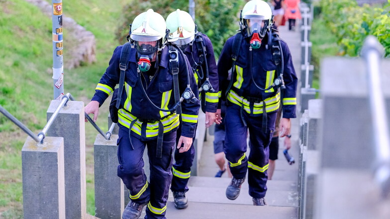 Kameraden der Radebeuler Feuerwehr erklimmen in kompletter Einsatzkleidung und mit Atemschutzgeräten die Spitzhaustreppe. Dieses Training dient einem überlebenswichtigen Gefühl.
