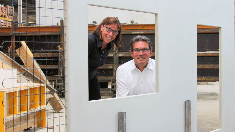 Hier schauen Birgit Zocher (links) und Matthias Schurig, die beiden Geschäftsführer des Betonwerkes Oschatz, durch ein Fenster eines Betonteils, aus dem noch das Carbon herausragt. Die Platte ist mit drei Zentimetern Stärke viel dünner als Stahlbeton.