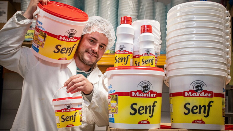 Sebastian Wagner mit den größeren Abpackungen der Senfeimer. Diese werden unter anderem von Großküchen oder der Gastronomie geordert.