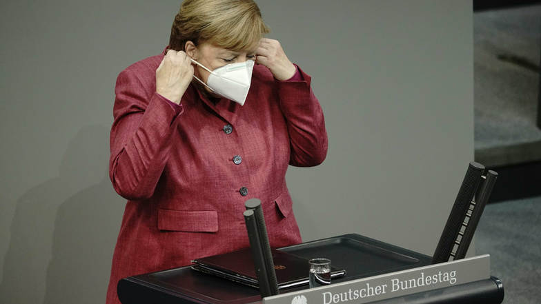 Bundeskanzlerin Angela Merkel (CDU) nimmt vor der Regierungserklärung zur Bewältigung der Corona-Pandemie die Maske ab.