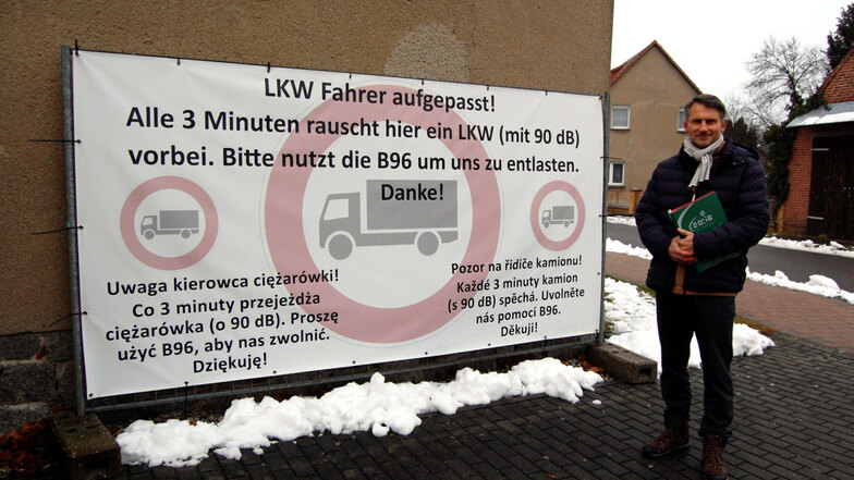 Mike Braun vom Burger Ortschaftsrat vor einem der Ende 2019 im Dorf platzierten Plakate, die Lkw-Fahrer bitten, den Ort möglichst zu meiden.