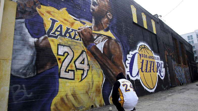 Ein Fan trauert vor einem Wandbild in Los Angeles, das den Basketballspieler Kobe Bryant darstellt. Bryant ist am Sonntag bei einem Hubschrauberabsturz in Kalifornien tödlich verunglückt.