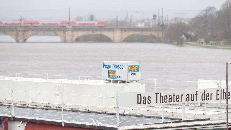 Der Pegelstand der Elbe steigt weiter, viele Schaulustige beobachten die Anzeige auf dem Theaterkahn.