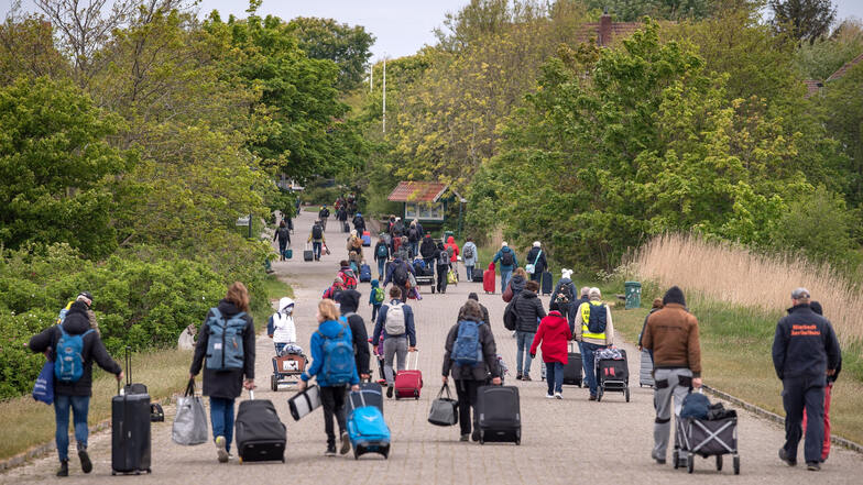 Touristen mit Koffern laufen über die Insel Spiekeroog: Zahlreiche Menschen haben die Tourismus-Lockerungen diese Woche genutzt und sind zum Urlaub auf die Ostfriesischen Inseln gefahren.
