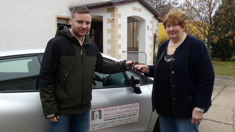 Monika Paschke übergibt symbolisch den Fahrzeugschlüssel an ihren Enkel Georg Paschke. Der will den Pflegedienst mit Sitz in Königswartha im Sinne seiner Oma weiter führen.
