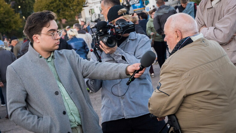 Reporter Max Roland (grauer Mantel) und sein Kameramann waren am Dienstag in Riesa unterwegs, um Menschen zur Insolvenz des Seifenwerks zu befragen.