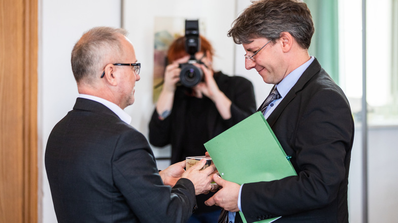 Hoyerswerdas Oberbürgermeister Stefan Skora (links) schenkt Alexander Schule einen Krabat-Raben.