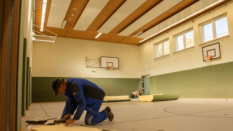 In der Sporthalle der Oberschule Kupferberg sind Bauarbeiter fleißig am Werkeln - hier Udo Kutzner. Doch die Arbeiten dauern länger als geplant.