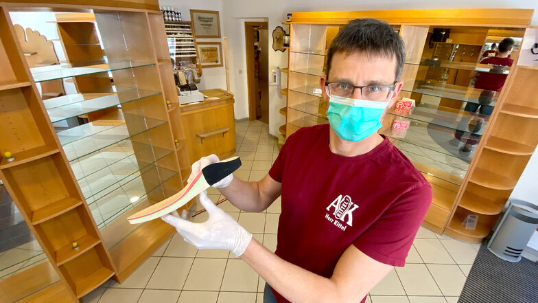 Orthopädieschuhmachermeister Alexander Kittel mit Mundschutz und Handschuhen in seinem leergeräumten Laden. Die Abläufe werden hier jetzt anders organisiert, um die Kunden zu schützen.